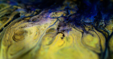 Glitter fluid drip. Shiny ink. Defocused black blue yellow color metallic shimmering dust particles oil emulsion dye paint spill abstract art background.