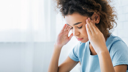 African-american woman suffering from headache at home