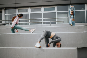 Three women engaging in a fitness routine on outdoor steps, with a focus on yoga and stretching...