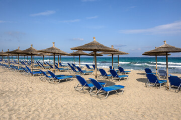 Sun loungers on the Marmari beach on the island of Kos. Beautiful sandy beach with turquoise...