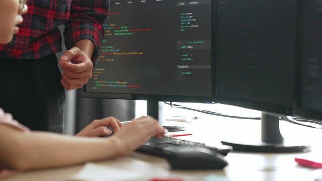 Slow motion back end or software developer manager supervising his team on new application program development on debugging and solving complex code algorithms on monitor. Burgeoning