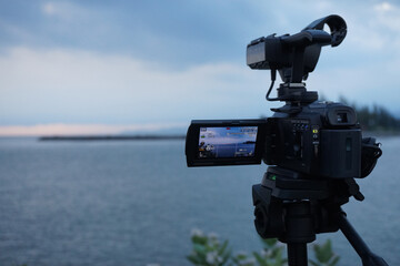 A camcorder mounted on a tripod is recording video