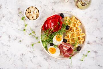 English breakfast. Boiled egg, jamon, waffles and green herbs. Top view, flat lay - 779142215