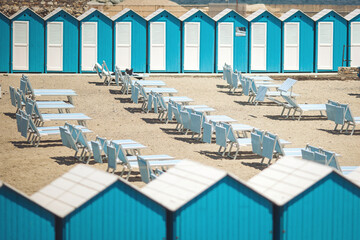 beach with its wooden cabins and umbrellas or parasol at a public beach. Beach cabins on the famous...