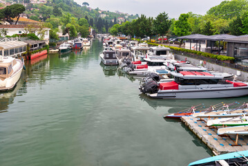 Naklejka premium Group of different shapes, sizes and colors boats docked in Goksu Stream, beside Anadolu Hisari historic castle on the Asian side of the Bosphorus in Istanbul, Turkey