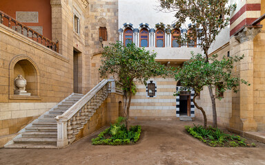 Fototapeta na wymiar Courtyard of Prince Naguib Palace, Cairo, Egypt where lush greenery and elegant architecture create a peaceful sanctuary. The inviting staircase beckons exploration