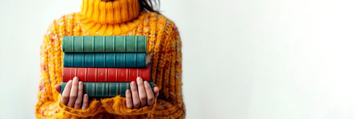 Woman in a yellow sweater with a stack of books. Concept of education, reading, knowledge, and library collection. White backdrop. Banner, copy space