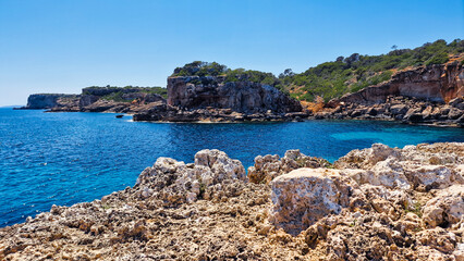 Rocky Coastline with Azure Waters and Cliffs in Bright Sunlight at S'Almonia, Malorca, Spain