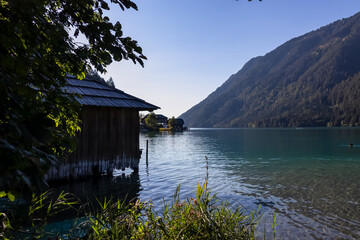 Wooden bathing house at east bank of alpine lake Weissensee in Gailtal Alps, Carinthia, Austria....