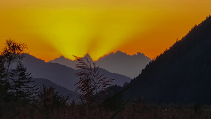 Silhouette of majestic mountain peaks against backdrop of vibrant sunset. Panoramic viewing point...