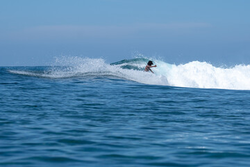 Surfers enjoy a sunny day and ride the big waves