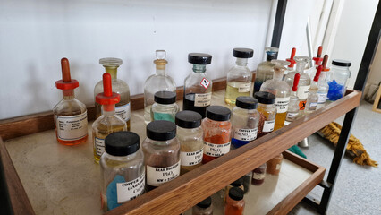Educational chemistry chemical bottles on a wooden shelf