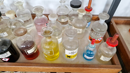 Educational chemistry chemical bottles on a wooden shelf
