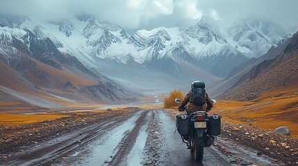 A man rides a motorcycle through the mountains, navigating winding roads
