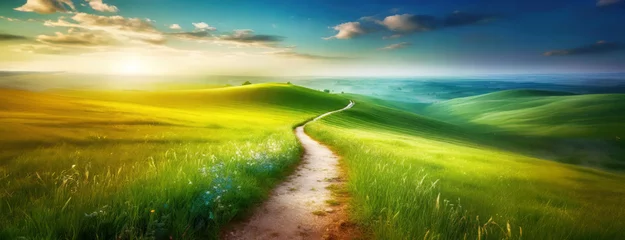 Foto auf Acrylglas Winding path cuts through verdant hills under a sunset sky, evoking a peaceful journey. Sunlight bathes the landscape in warmth, highlighting nature's contours and flora. Panorama with copy space. © Igor Tichonow