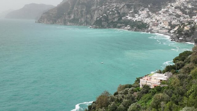 Vista dall'alto della costiera amalfitana verso la spiaggia di Positano mentre la spiaggia viene sferzata da una forte tempesta