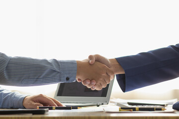 Businessmen and investors shake hands as symbol of joint venture after discussing, consulting and...