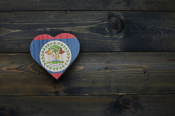wooden heart with national flag of belize on the wooden background.
