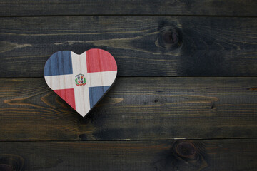 wooden heart with national flag of dominican republic on the wooden background.