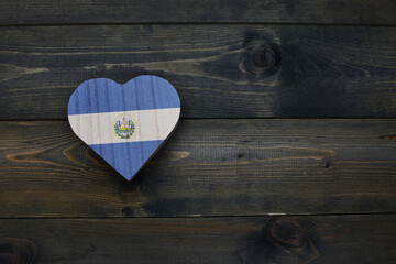 wooden heart with national flag of el salvador on the wooden background.