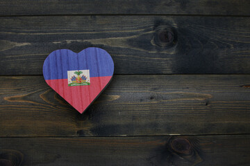 wooden heart with national flag of haiti on the wooden background.