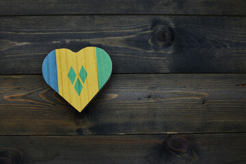 wooden heart with national flag of saint vincent and the grenadines on the wooden background.