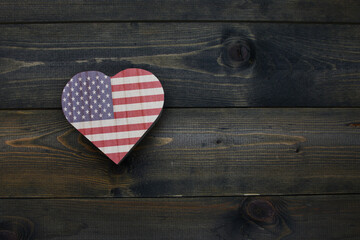 wooden heart with national flag of united states of america on the wooden background.