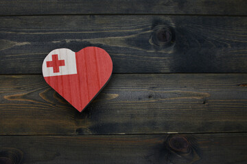 wooden heart with national flag of Tonga on the wooden background.