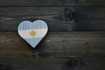 wooden heart with national flag of argentina on the wooden background.