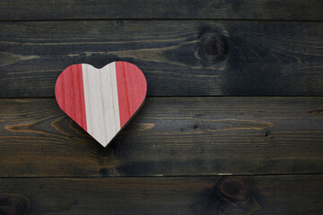 wooden heart with national flag of peru on the wooden background.