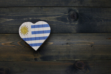 wooden heart with national flag of uruguay on the wooden background.