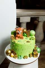 Sweet green cake with a tiger figurine for a one year old baby