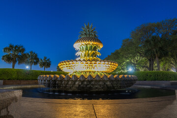 The Pineapple Fountain in Charleston, SC, illuminated at twilight with a crescent moon and Venus in the early evening sky.