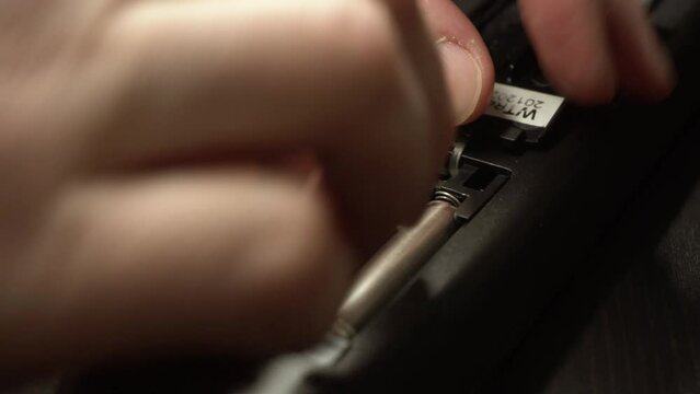 Insert new batteries into remote control. AAA batteries loading into a remote control. Close-up.
