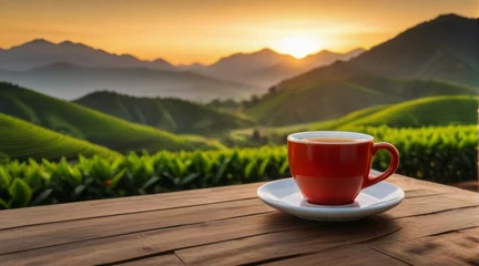 Fotobehang Cup of hot tea with sacking on the wooden table and the tea plantations background © master old