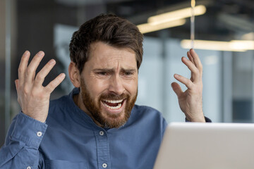 Frustrated man experiencing computer problems at work