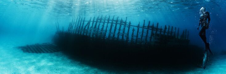 Silhouette of free diver exploring ship wrack. - 779203213