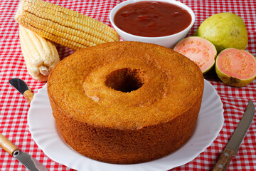 corn cake on white plate on rustic wooden table. Typical Brazilian party food.