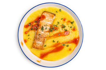 Polenta with grilled salmon and tomato sauce on ceramic plate.