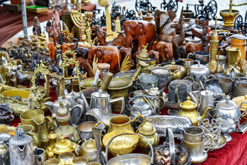 Fototapeta na wymiar Set of silver, brass and copper utensils: jugs, teapots, bowls on flea market