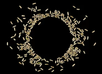 Foto op Canvas Brown rice, uncooked and hulled in shape circle, isolated on black, top view  © dule964