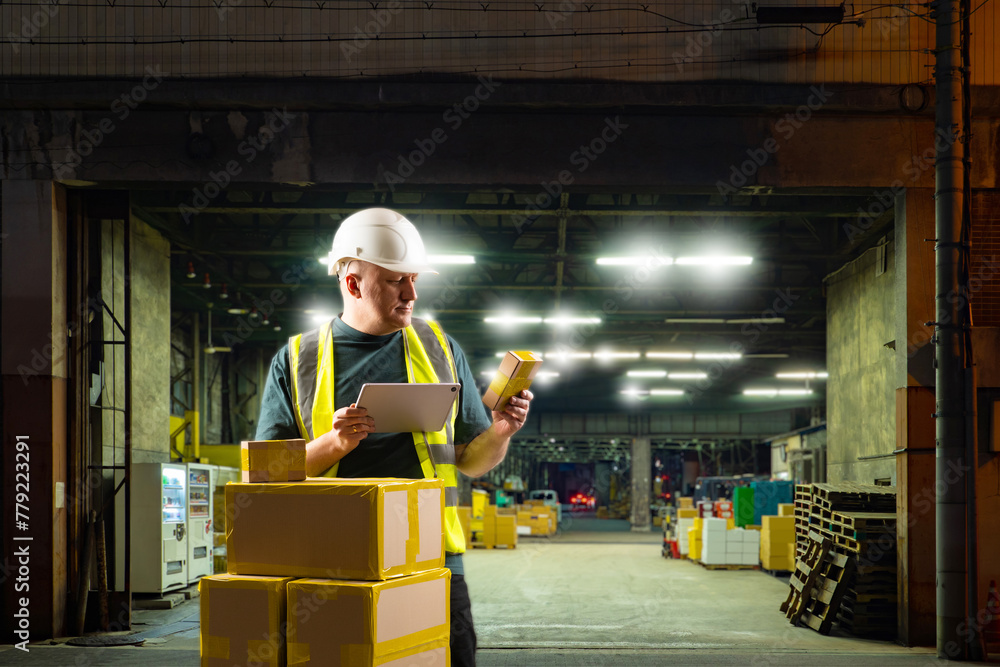 Poster man loader at industrial enterprise. guy with boxes near factory gate in evening. warehouseman accep