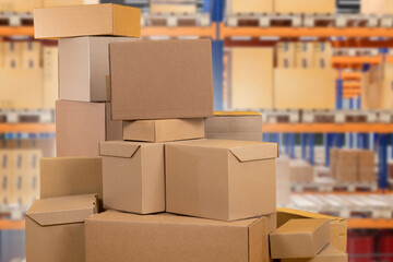Cardboard boxes. Bunch of parcels at courier warehouse. Delivery service storage. Stack of boxes near warehouse racks. Cardboxes await placement in addressable storage system. Selective focus