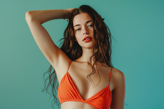 Beautiful woman in a bikini posing in front of a blue background. Summer vipe.