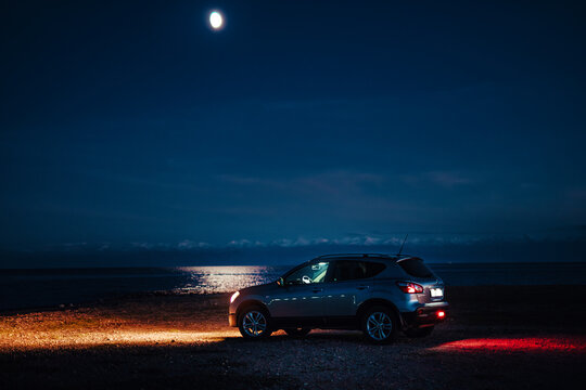 Nissan Qashqai car on the lake shore at night time