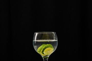 A glass bowl with water and lemon slices inside.