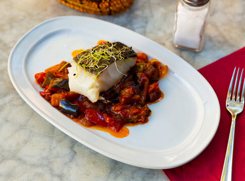Popular dish of Spanish cuisine is Bacala, made from fish with vegetables and decorated with greenery on top