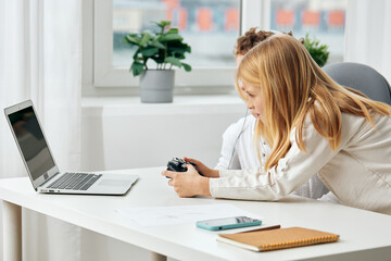 Boy and Girl Studying Online with Laptops in a Cozy Living Room