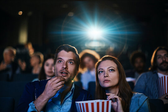 Young couple watching film in movie theater