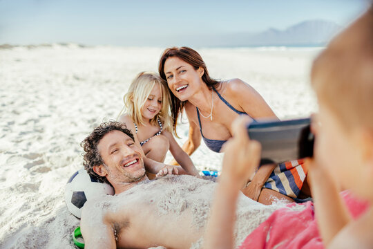 Family enjoying beach day and taking photos